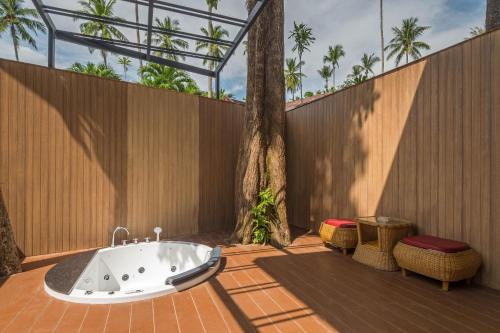 奥南海滩Aonang Paradise Resort Krabi的浴缸位于围栏旁的庭院