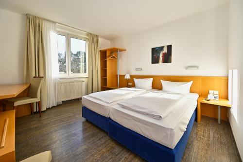 策勒HESSE HOTEL Celle的一间卧室配有一张大床和一张书桌
