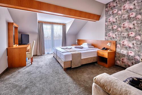 尼赖吉哈佐Lugas Hotel的酒店客房,配有床和电视