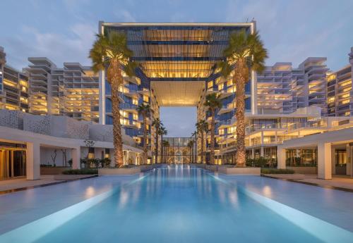 迪拜FIVE Palm Jumeirah Resort - 2 Bedrooms plus Maids and Private Jacuzzi - ModernLux的一座大型建筑,设有棕榈树游泳池