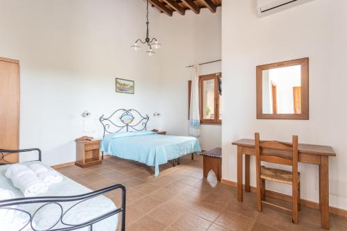 San SalvatoreAgriturismo S'Incant'e Sinis的一间卧室配有一张床、一张书桌和一面镜子