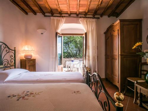 拉达-因基安蒂玛尔蓬萨塔农家乐的一间卧室设有两张床和窗户。