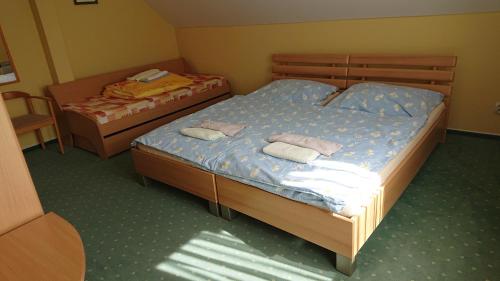 鲁容贝罗克Penzion pod Vlkolíncom的小房间设有两张单人床,配有背风性关节炎性关节炎性关节炎