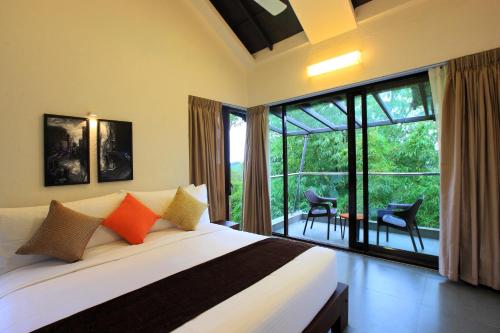 瓦加蒙Tea Terrain Resorts & Spa的一间卧室设有一张床和一个大窗户