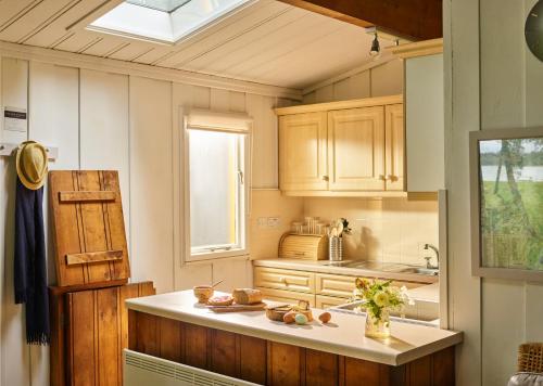 门蒂斯港洛肯德小木屋假日公园的厨房配有木制橱柜、水槽和窗户。