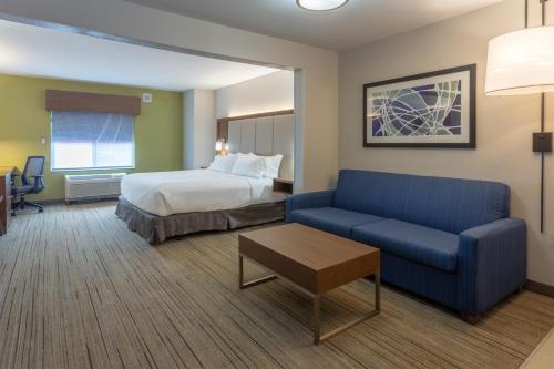 密尔沃基Holiday Inn Express & Suites Milwaukee NW - Park Place, an IHG Hotel的酒店客房,配有床和蓝色的沙发