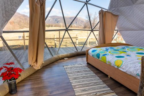 VăraticiBrancoveanu Glamping的帆布帐篷内的一张床位,配有窗户