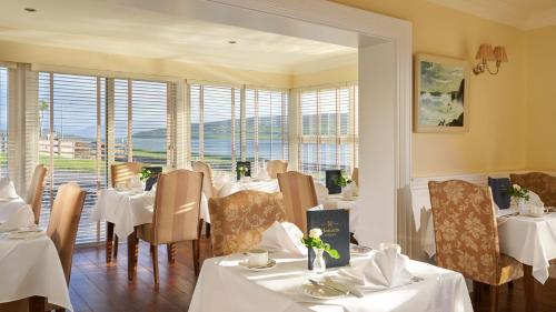 丁格尔锡顿斯旅馆的餐厅设有白色的桌椅和窗户。