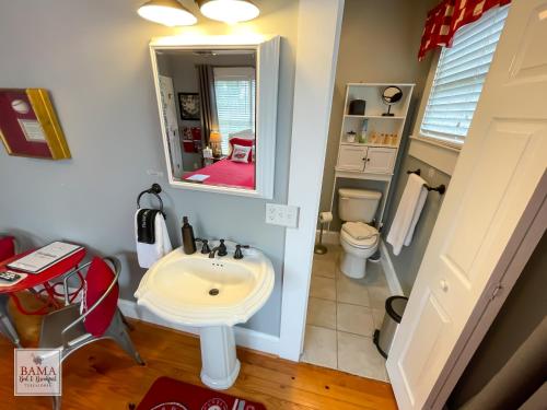 塔斯卡卢萨Bama Bed and Breakfast - Sweet Home Alabama Suite的一间带水槽、卫生间和镜子的浴室
