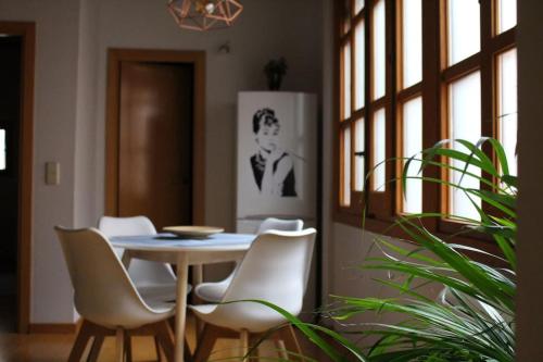 托莱多La Casa de Sillería的一间带桌子和白色椅子的用餐室