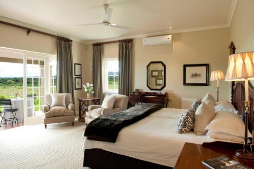 阿多河湾旅馆的一间卧室配有一张大床和一张桌子及椅子