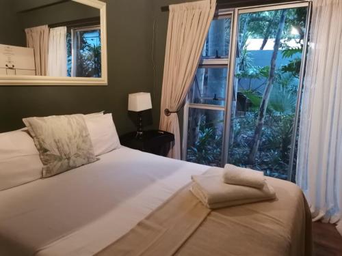 勒斯滕堡Bono Luxury Guesthouse的一间卧室设有一张床和一个大窗户