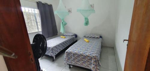 甘博阿Casa Azul Gamboa的带窗户的客房内设有两张单人床。