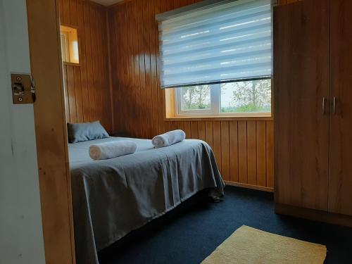 巴拉斯港Cabañas Quimantu-Aguas Calientes的一间卧室配有带毛巾的床
