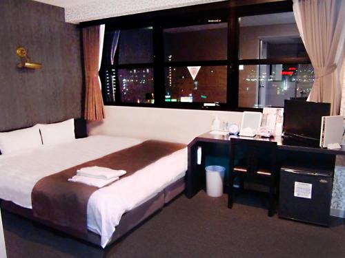 安约马奇雅蓓丝塔长野站前酒店的一间卧室配有一张带书桌的床和窗户。