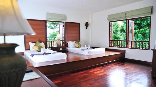清莱Teak Garden Resort, Chiang Rai的大房间设有两张床和两个窗户