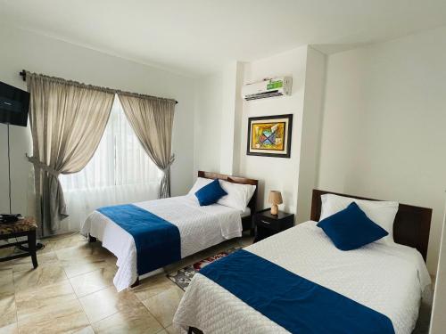 比亚米尔港Apartahotel Casa Soleil的一间卧室设有两张床和窗户。