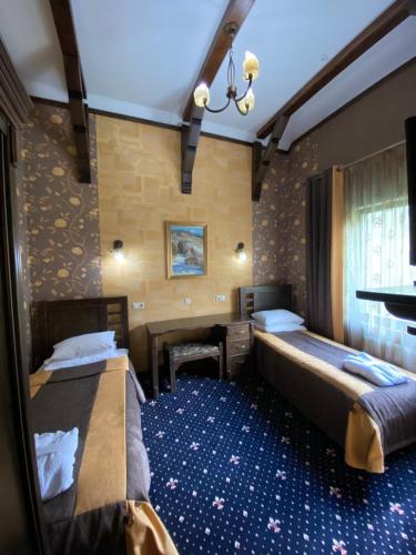 帕利亚尼西亚Шале в Буковелі的酒店客房设有两张床和一张桌子。