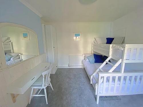 普里茅斯The Retreat @ The Old Smithy, Colebrook Village的一间卧室配有两张双层床、一张桌子和一面镜子