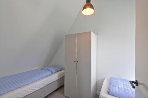 栋堡Vakantiehuis Poldertje 1A - Baddomburg的一间卧室配有一张床和一个橱柜