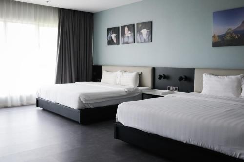 哥打京那巴鲁Inkk Hotel @ Aeropod by Pinstay的酒店客房设有两张床和窗户。