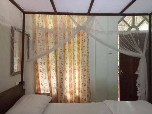 锡吉里亚Sigiriya Nature View home Stay的一间卧室配有床和带窗帘的窗户