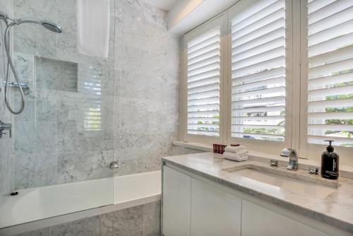 悉尼Premium Double Bay 3 bedroom apartment的带淋浴和盥洗盆的白色浴室