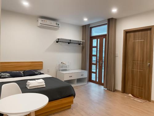 胡志明市B786 Airport Apartment的卧室配有1张床、1张桌子和1把椅子