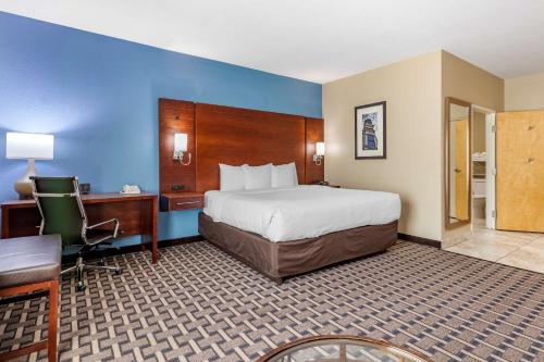乔治城乔治敦康福特套房酒店的酒店客房设有一张大床、一张书桌和一张书桌。