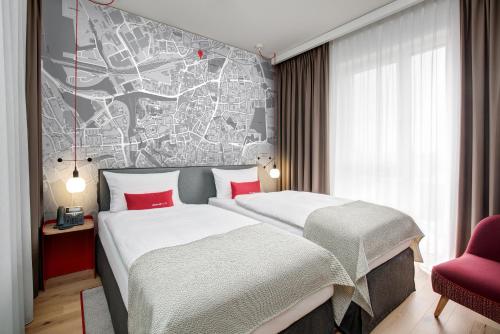多特蒙德IntercityHotel Dortmund的两张位于酒店客房的床,墙上有地图