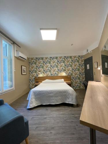 蒙彼利埃Hôtel Mistral Comédie Saint Roch的一间卧室配有一张床和一张蓝色的沙发