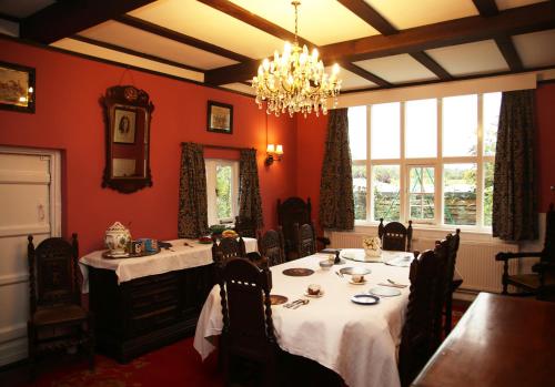 雷丁Inverloddon Bed and Breakfast, Wargrave的一间带2张桌子和吊灯的用餐室