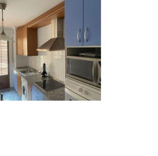 洛斯科拉莱斯-德布埃尔纳8 de abril的厨房配有蓝色橱柜和炉灶烤箱。