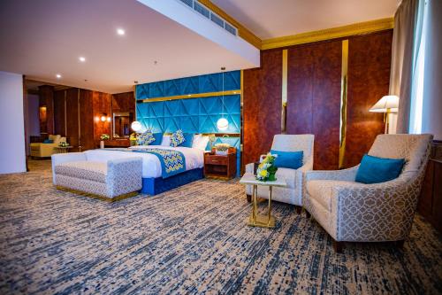 奈季兰Le Park Concord Hotel & Resident Najran的酒店客房,配有一张床和两把椅子