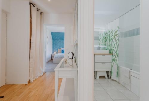 圣阿尔努Appartement 2 chambres aux portes de Deauville 100m du Pôle International du cheval的白色的浴室设有水槽和镜子