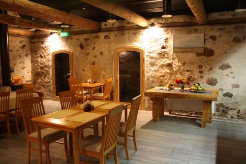 罗亚若德利旅馆的拥有木桌和椅子以及石墙的餐厅