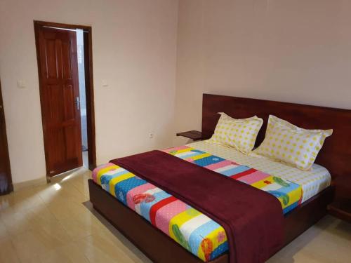 雅温得Appartement chic au quartier Omnisport的一间卧室配有一张大床和色彩缤纷的毯子