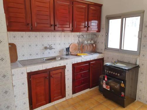 雅温得Appartement chic au quartier Omnisport的厨房配有红色橱柜、水槽和炉灶。