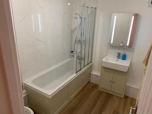 SouthwickAdorable One-Bedroom Flat With Patio Garden.的带淋浴和盥洗盆的白色浴室