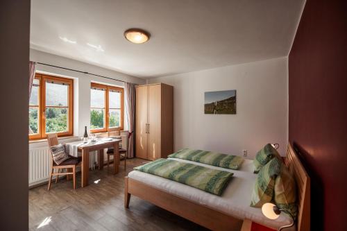 瓦豪地区魏森基兴Winzerhof & Gästehaus Bernhard的一间卧室配有一张床、一张桌子和一张桌子