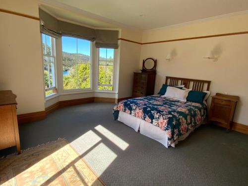 Port FitzroyGlenfern Sanctuary的一间卧室设有一张床和两个窗户。