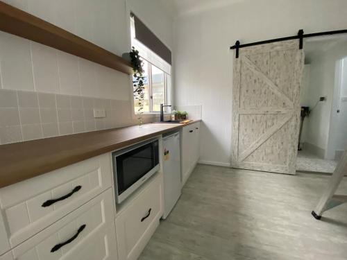 蒂默特Studio 69 on Capper的厨房配有白色橱柜和滑动谷仓门。
