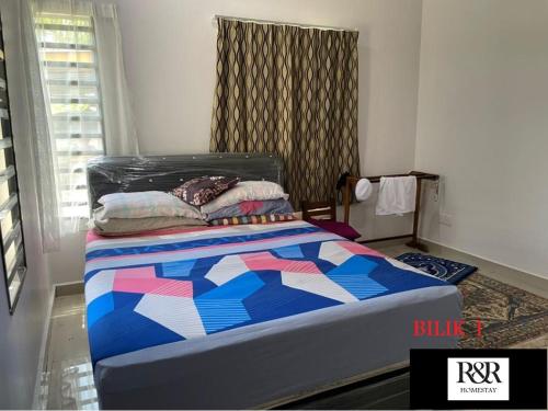 Tanjung KarangR & R HOMESTAY的一间卧室,床上有五颜六色的被子