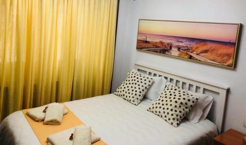 纳瓦塞拉达Navarubia的卧室配有一张床,墙上挂有绘画作品