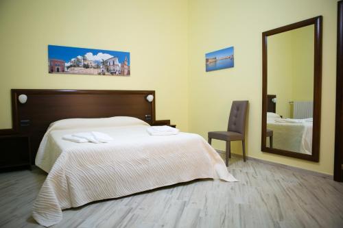 帕拉比塔Villa Albertina Exclusive B&B的一间卧室配有一张带镜子和椅子的床