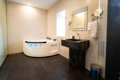 吉赞Garden Millennium Hotel的带浴缸和盥洗盆的浴室