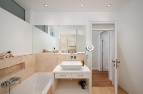 纽伦堡Deluxe Apartments Christina 120 m² im Design Hotel Vosteen的浴室配有盥洗盆和浴缸。
