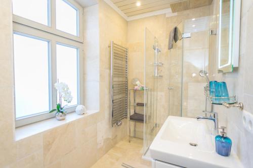 韦斯特兰Aschenputtel的带淋浴和盥洗盆的浴室以及窗户。