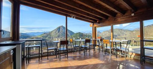 坎加斯-德奥尼斯Hotel Granja Paraíso, Oasis Rural & Bienestar的一间设有桌椅的山景阳台客房