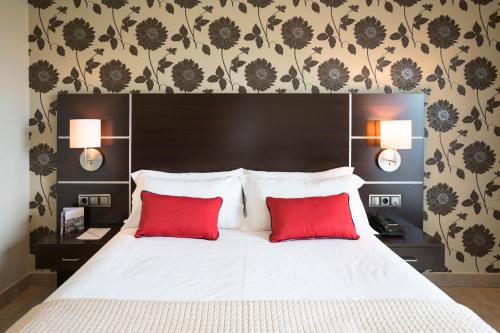 波多诺伏皮拉米德2酒店的一间卧室配有一张带两个红色枕头的床